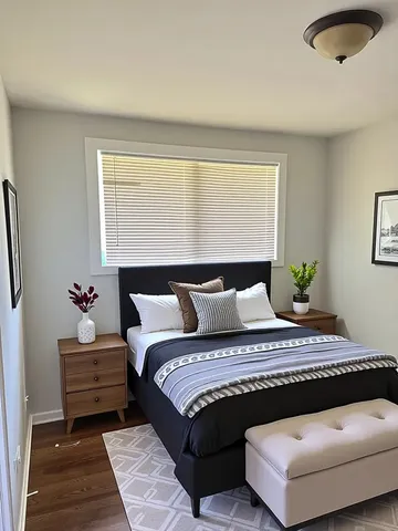 a bedroom with a bed and wooden floor