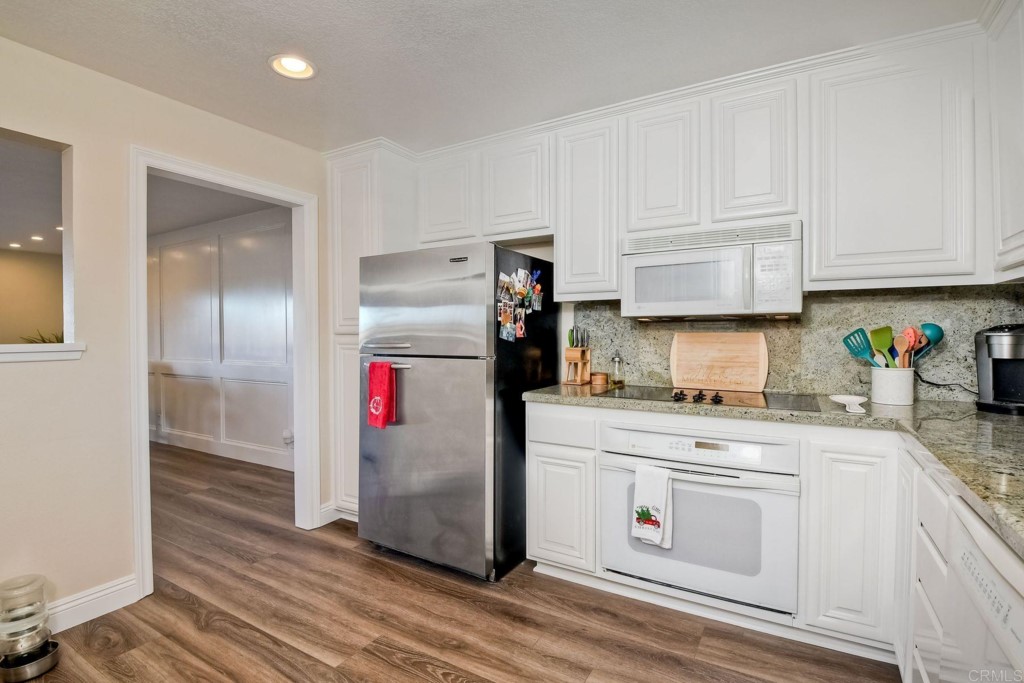 4705 Marina Drive, Unit 5 Carlsbad, CA 92008 - Photo 14 of 30 a kitchen with stainless steel appliances granite countertop a refrigerator a stove and white cabinets
