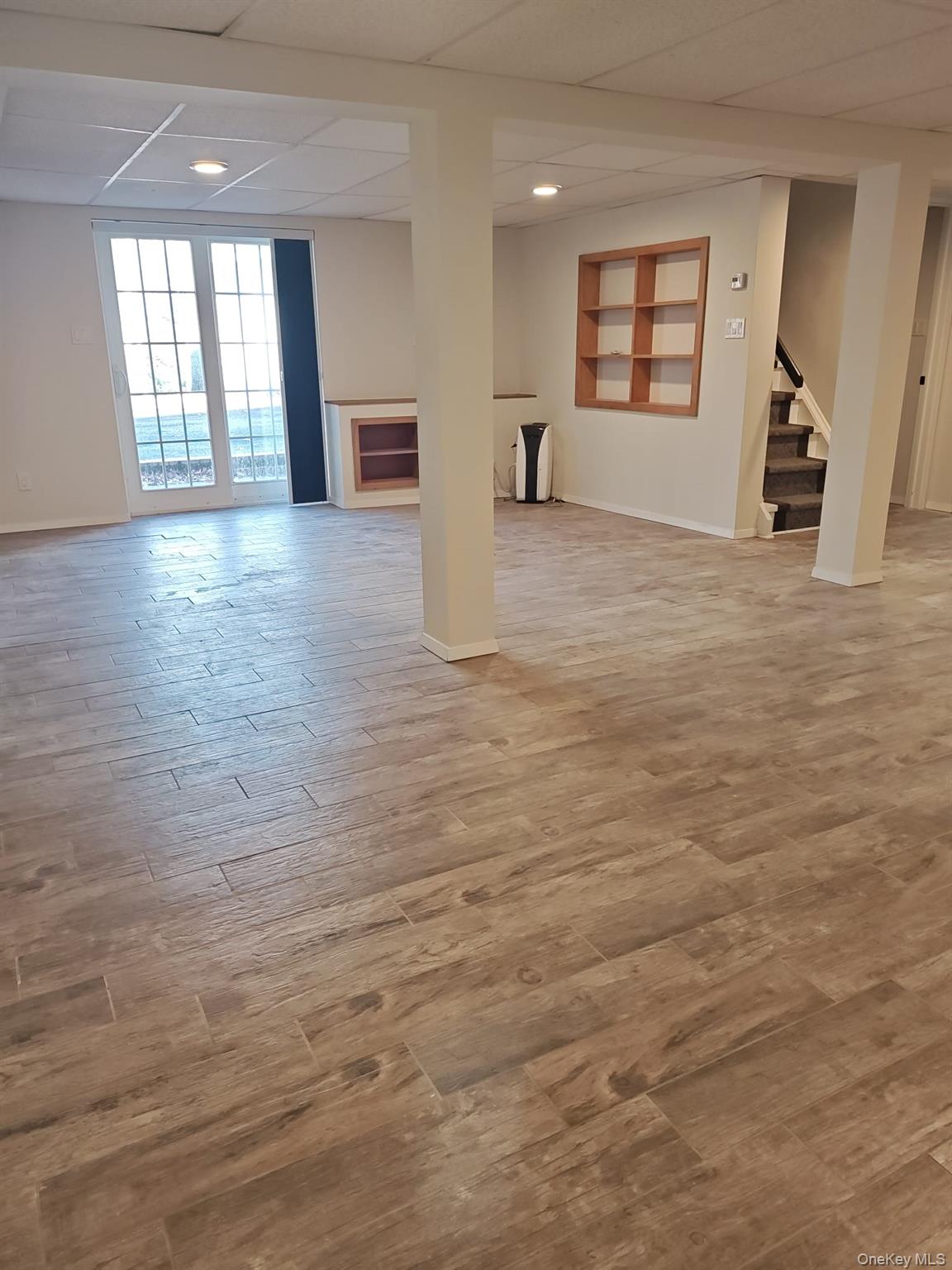 2354 North Wading River Road Wading River, NY 11792 - Photo 17 of 20 Basement with light wood-style flooring, stairs, recessed lighting, and a paneled ceiling