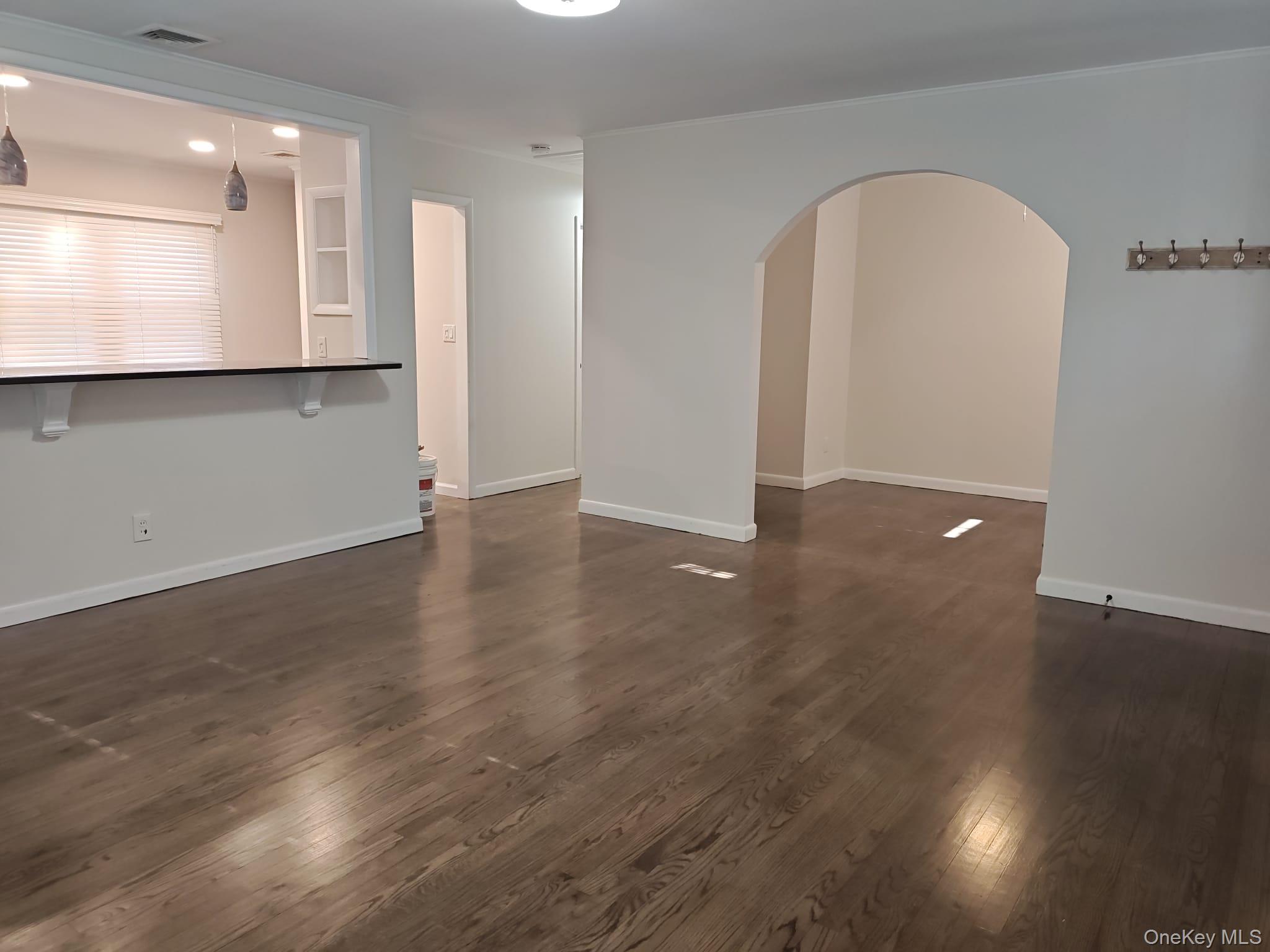 2354 North Wading River Road Wading River, NY 11792 - Photo 3 of 28 Unfurnished living room featuring arched walkways, dark wood finished floors, and recessed lighting
