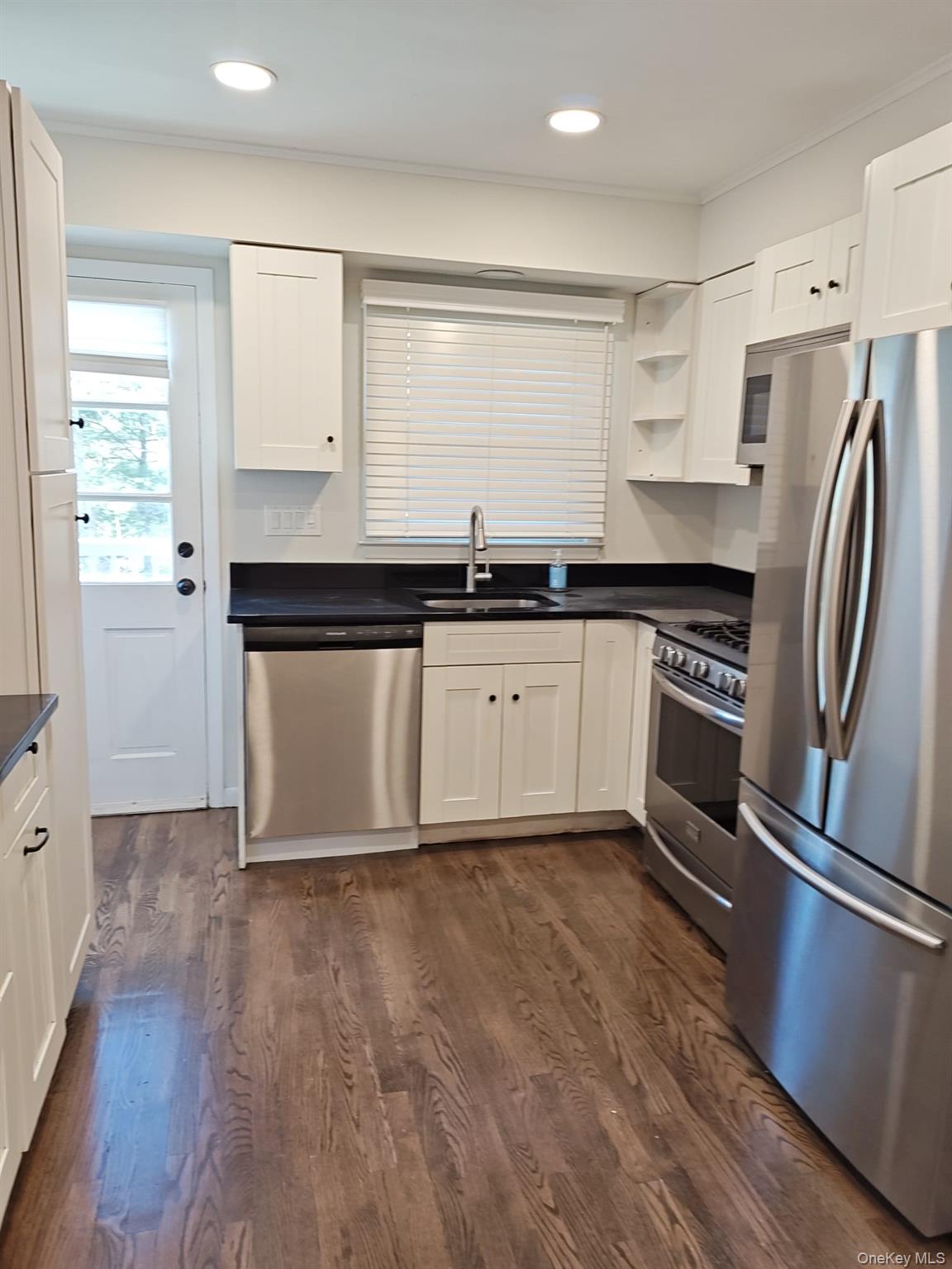 2354 North Wading River Road Wading River, NY 11792 - Photo 6 of 20 Kitchen with appliances with stainless steel finishes, white cabinets, dark wood-type flooring, ornamental molding, and recessed lighting