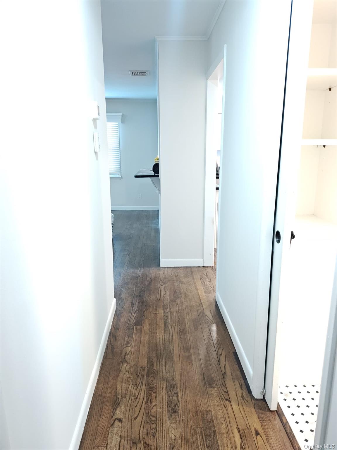 2354 North Wading River Road Wading River, NY 11792 - Photo 7 of 20 Hallway with dark wood-style flooring and ornamental molding
