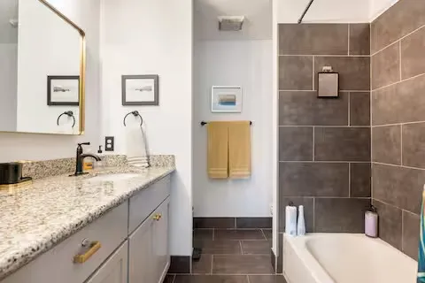 a bathroom with a granite countertop sink a toilet and mirror