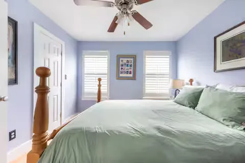 a bedroom with a bed and painting on the wall