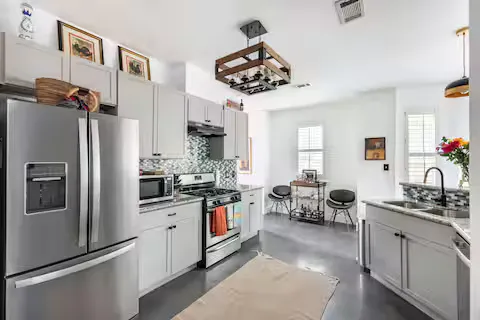 a kitchen with stainless steel appliances a sink a stove and refrigerator