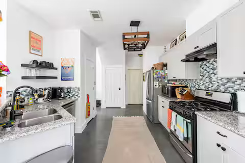 84 Anthony Street Austin, TX 78702 - Photo 9 of 17 a kitchen with stainless steel appliances granite countertop a sink stove and refrigerator