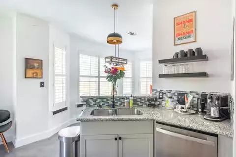 a kitchen with stainless steel appliances granite countertop a sink a stove and a wooden floor