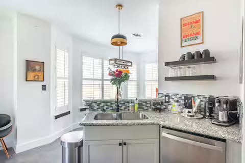 84 Anthony Street Austin, TX 78702 - Photo 10 of 17 a kitchen with stainless steel appliances granite countertop a sink a stove and a wooden floor