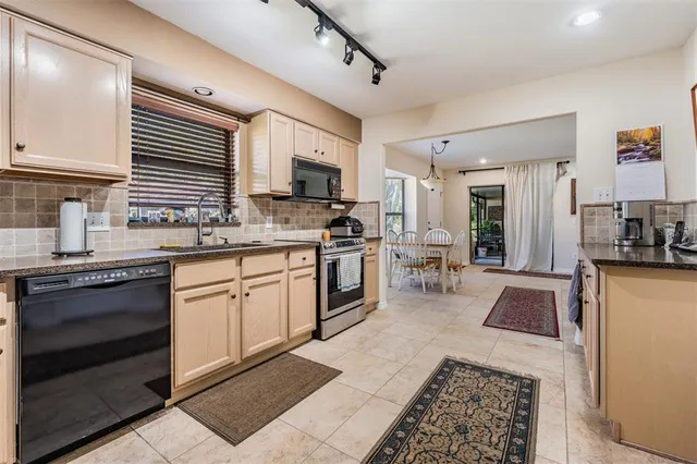 a kitchen with stainless steel appliances granite countertop a stove a sink and a microwave