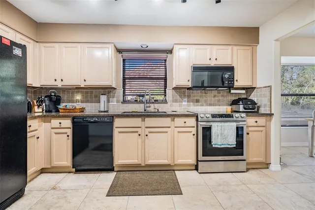 a kitchen with stainless steel appliances granite countertop a refrigerator stove and sink