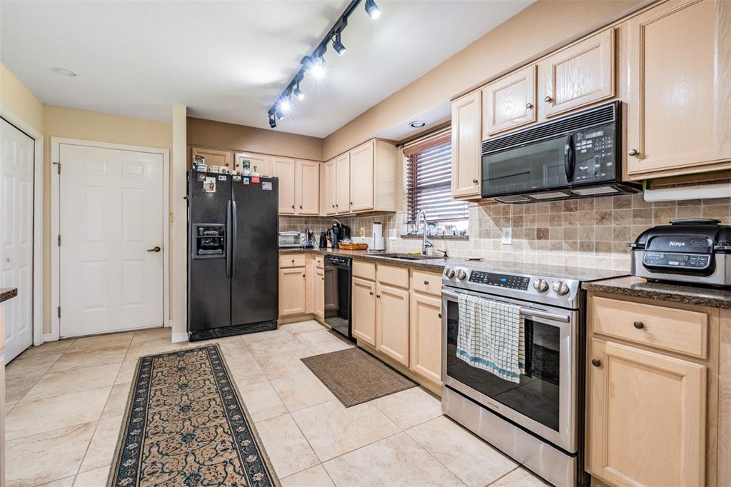 17569 Fairmeadow Drive Tampa, FL 33647 - Photo 7 of 60 a kitchen with stainless steel appliances granite countertop a refrigerator stove and sink