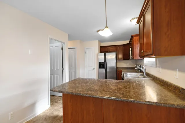 a kitchen with kitchen island a counter top space cabinets and stainless steel appliances