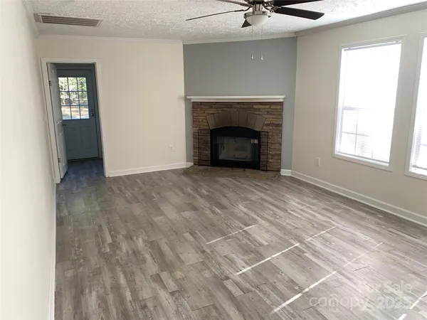 a view of an empty room with a fireplace and a window
