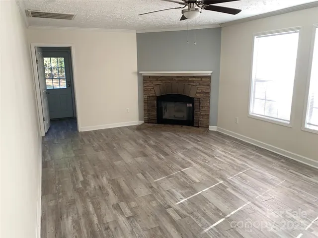 a view of an empty room with a fireplace and a window