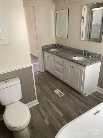a bathroom with a granite countertop toilet sink and mirror