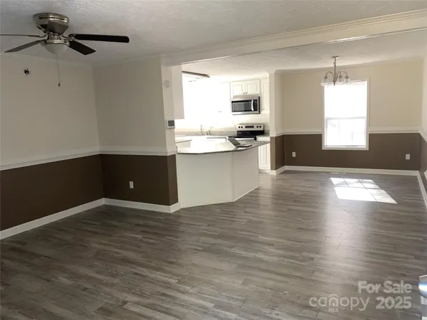 a view of kitchen and hall with wooden floor