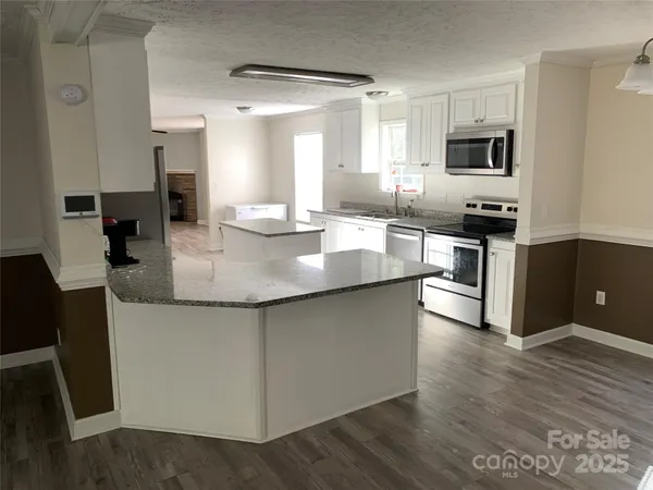 a large kitchen with granite countertop a stove and a sink
