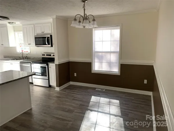 a kitchen with granite countertop a stove a sink and a microwave