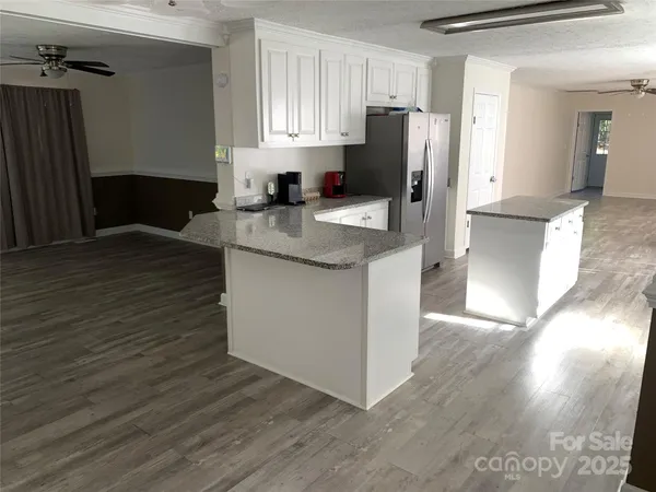 a kitchen with granite countertop a refrigerator and a stove top oven