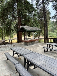 52358 Elder Road, Unit 52 Big Creek, CA 93605 - Photo 26 of 41 a view of a patio with table and chairs under an umbrella with large trees