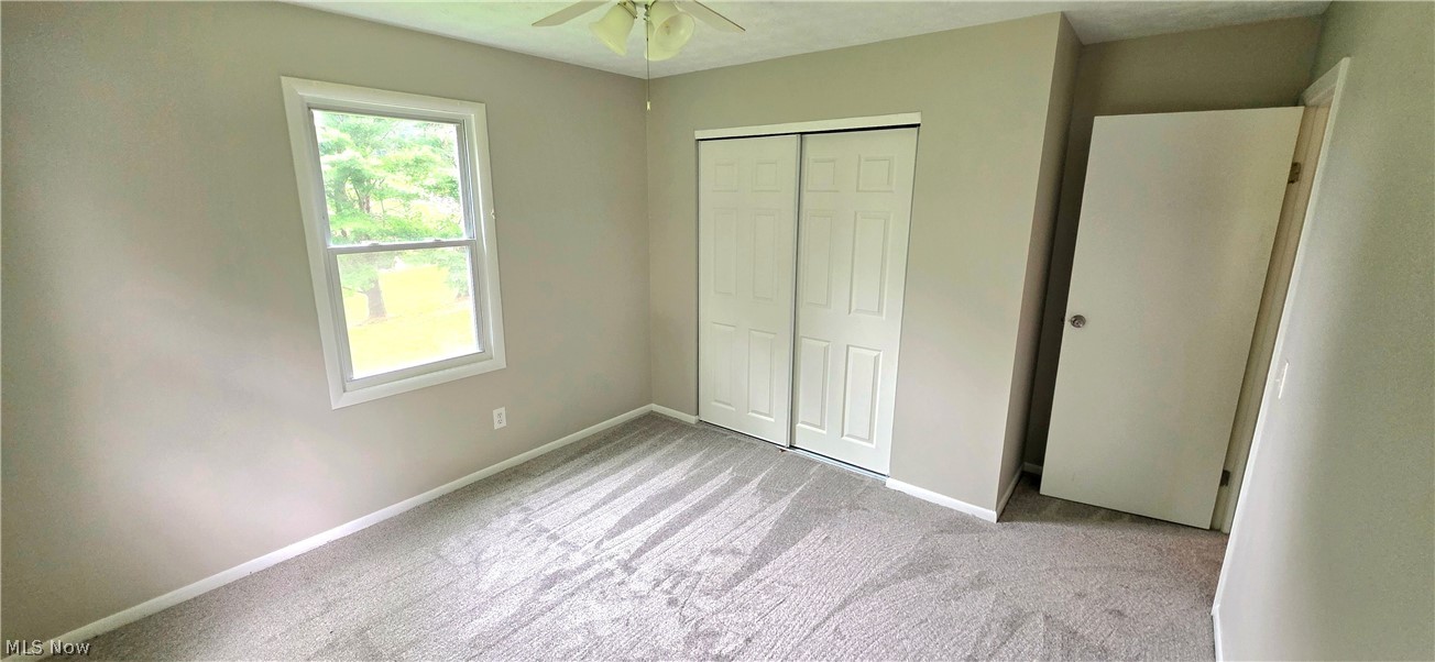 252 Saxe Road Mogadore, OH 44260 - Photo 16 of 24 Neutral-toned walls, white trim, sliding closet doors, and a ceiling fan