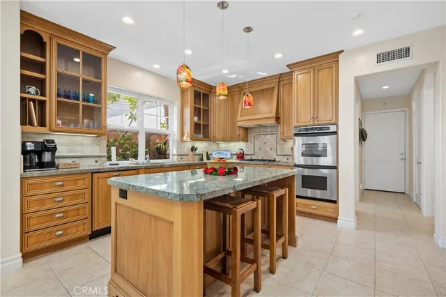 a kitchen with stainless steel appliances a sink counter space cabinets and a large window