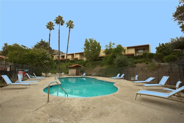 a view of a swimming pool with a bench and some trees