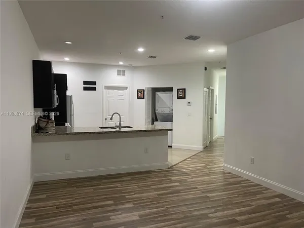 a view of kitchen with stainless steel appliances wooden floor