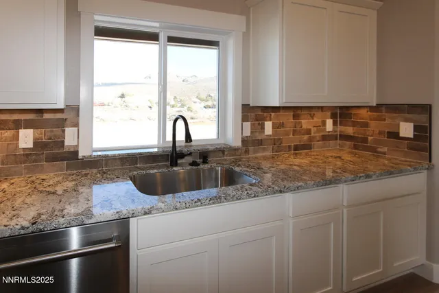 a kitchen with granite countertop a sink and a window