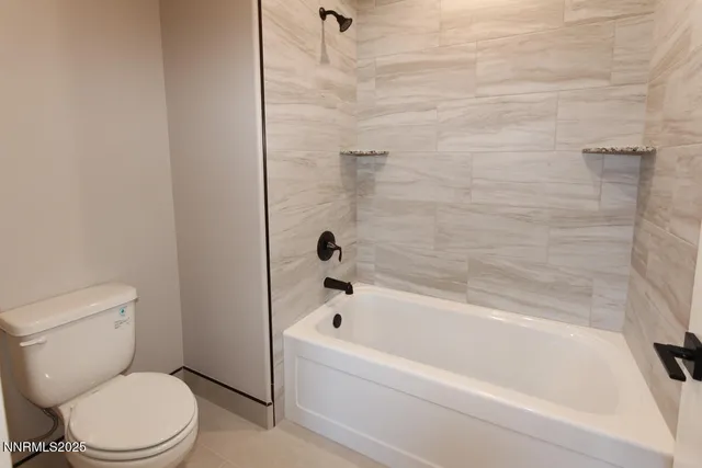 a white bath tub sitting next to a toilet