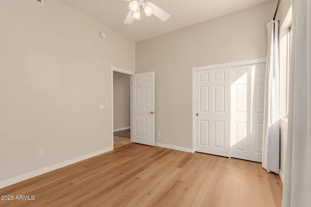 an empty room with wooden floor and windows