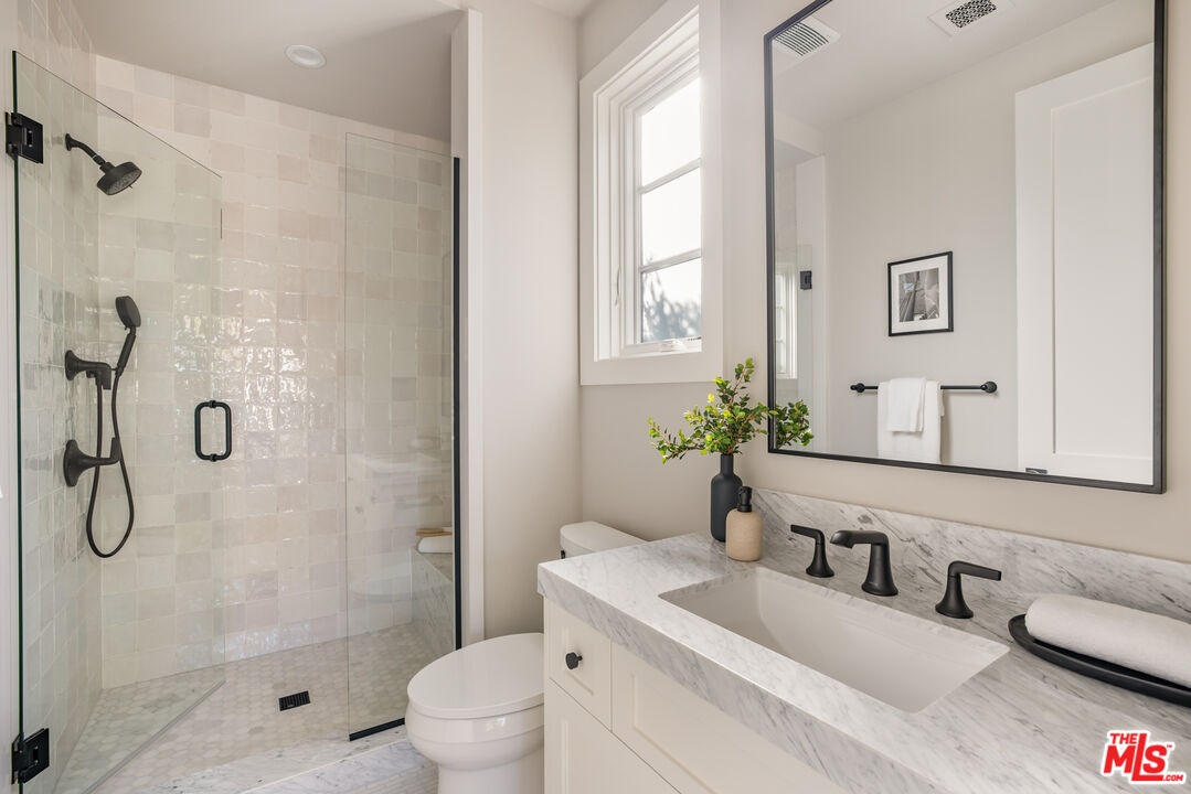 628 10th Street Santa Monica, CA 90402 - Photo 26 of 48 a bathroom with a granite countertop sink a toilet and shower