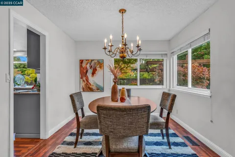 a dining room with furniture potted plants and wooden floor