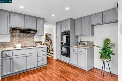 a kitchen with granite countertop white cabinets and white stainless steel appliances