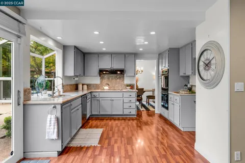 a kitchen with a refrigerator a sink a stove and cabinets