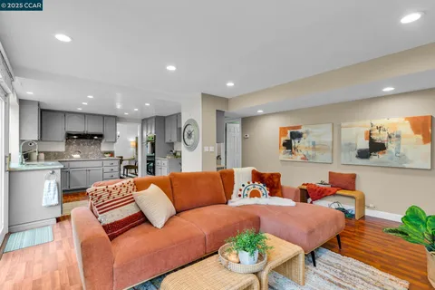 a living room with furniture kitchen view and a table