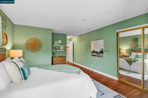 a bedroom with a bed and painting on the wall