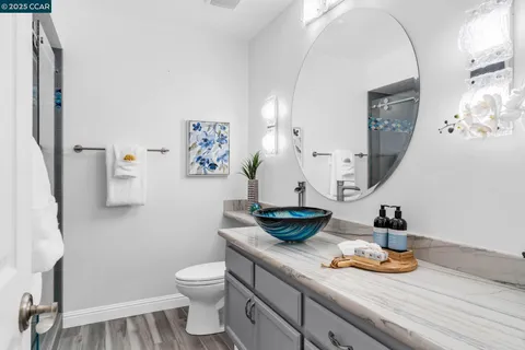 a kitchen with a sink and a stove with wooden floor