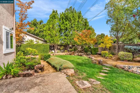 a backyard of a house with outdoor seating and trees