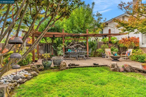 a view of a chair and table in backyard of the house