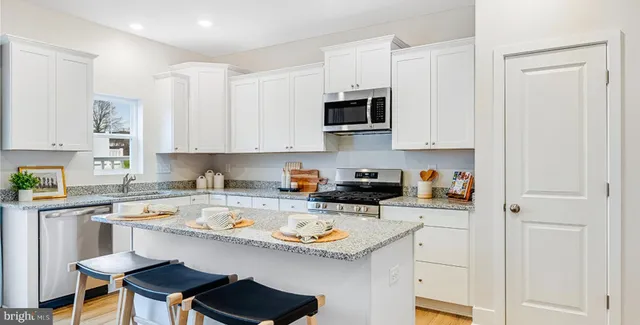 a kitchen with stainless steel appliances a stove a sink and cabinets