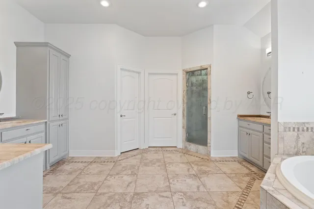 a spacious bathroom with a sink a mirror a bathtub and a shower