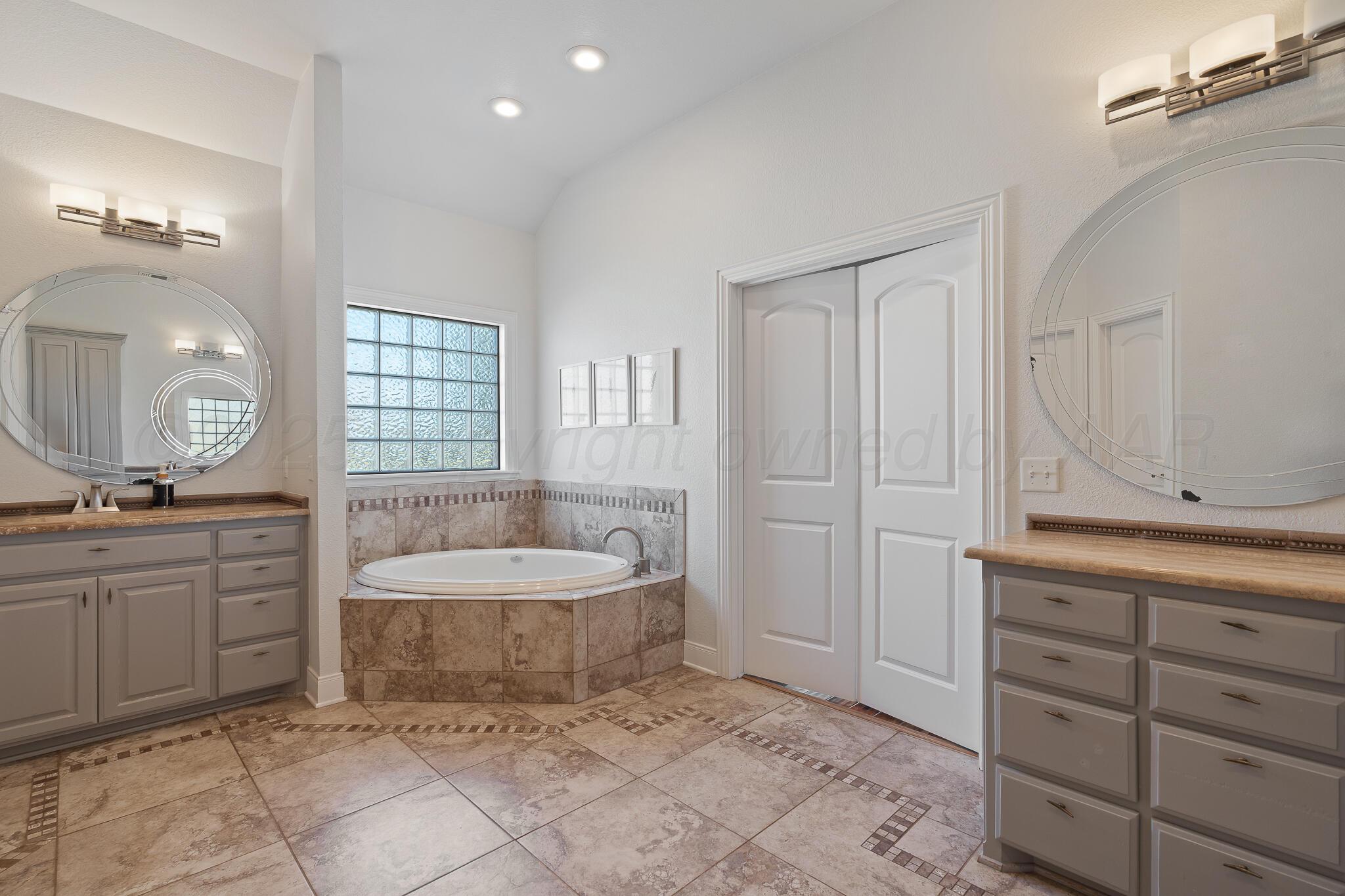 17301 Spring Lake Drive Canyon, TX 79015 - Photo 15 of 62 a spacious bathroom with a granite countertop sink a toilet mirror and bathtub