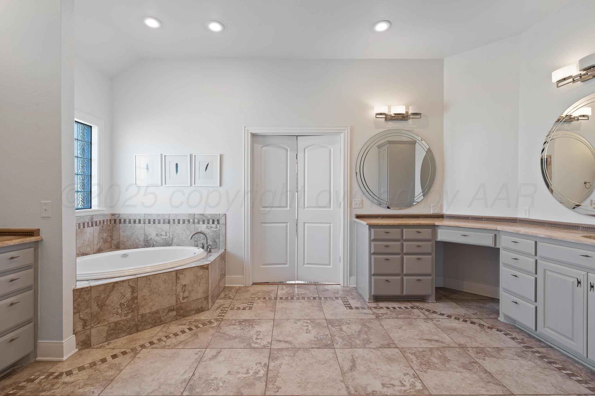 17301 Spring Lake Drive Canyon, TX 79015 - Photo 16 of 62 a spacious bathroom with a sink a mirror a bathtub and a shower