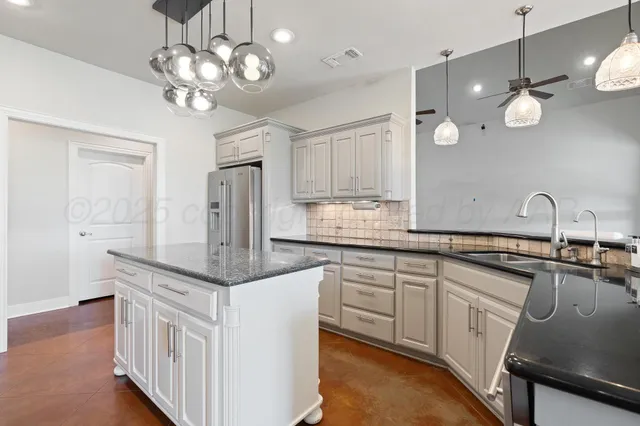 a kitchen with kitchen island a dining table and chairs