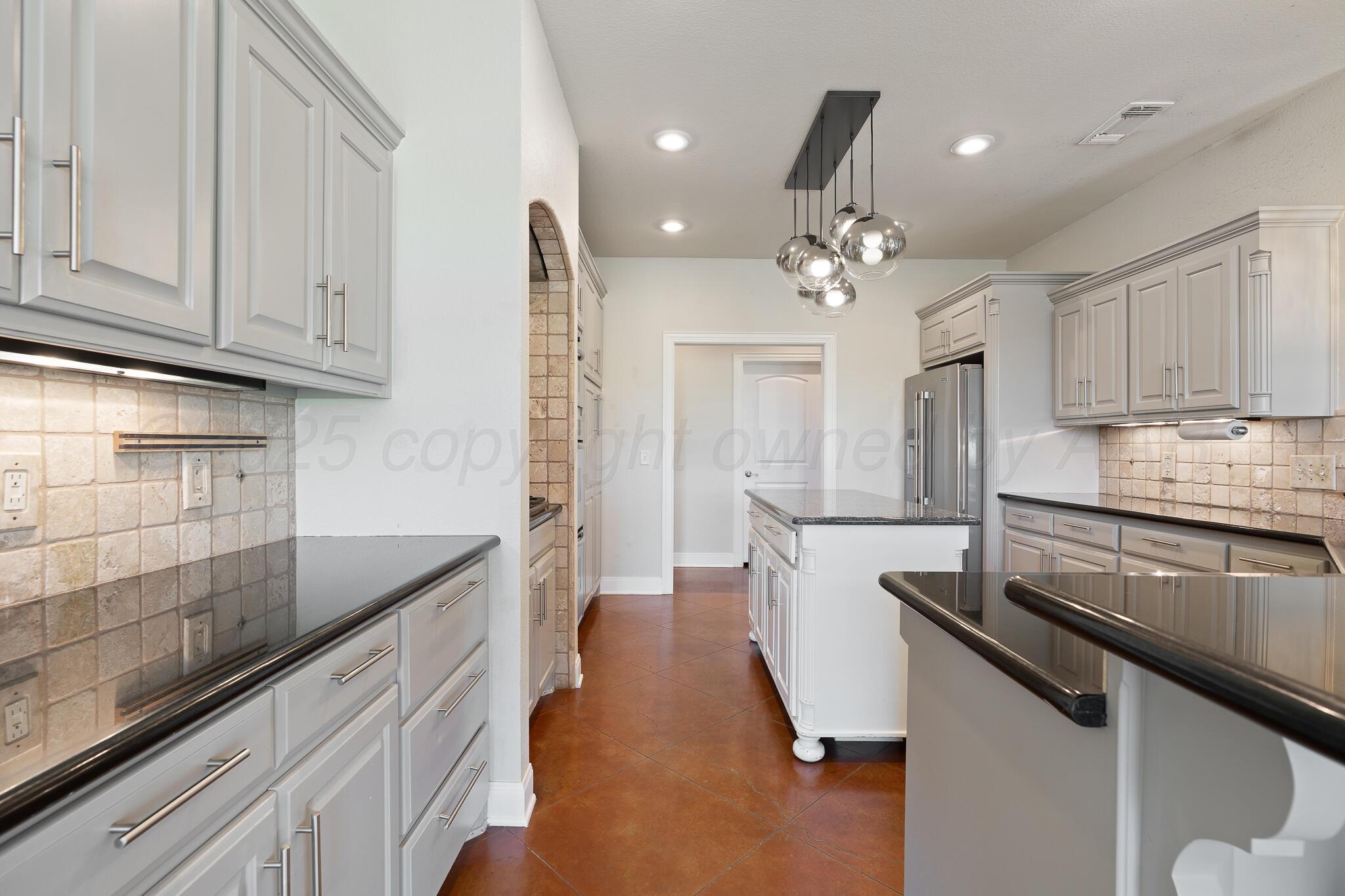 17301 Spring Lake Drive Canyon, TX 79015 - Photo 22 of 62 a kitchen with kitchen island granite countertop a sink cabinets and stainless steel appliances