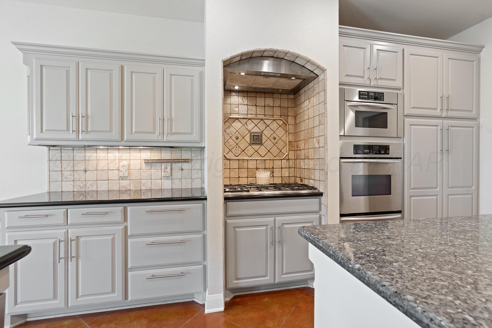 17301 Spring Lake Drive Canyon, TX 79015 - Photo 23 of 62 a kitchen with granite countertop white cabinets and stainless steel appliances