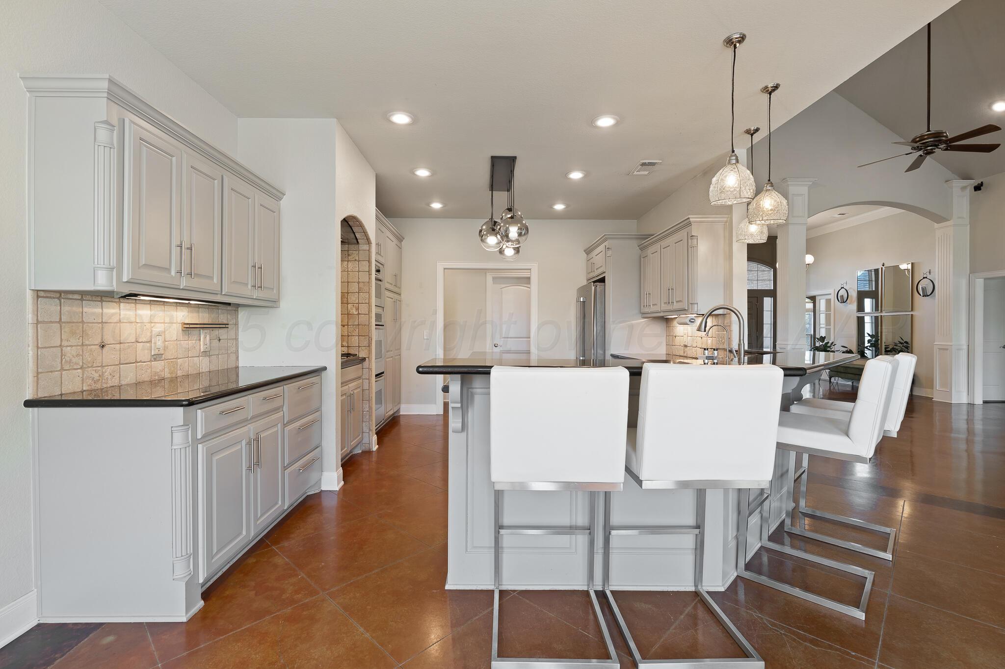 17301 Spring Lake Drive Canyon, TX 79015 - Photo 24 of 62 a large white kitchen with lots of counter space wooden floor and appliances