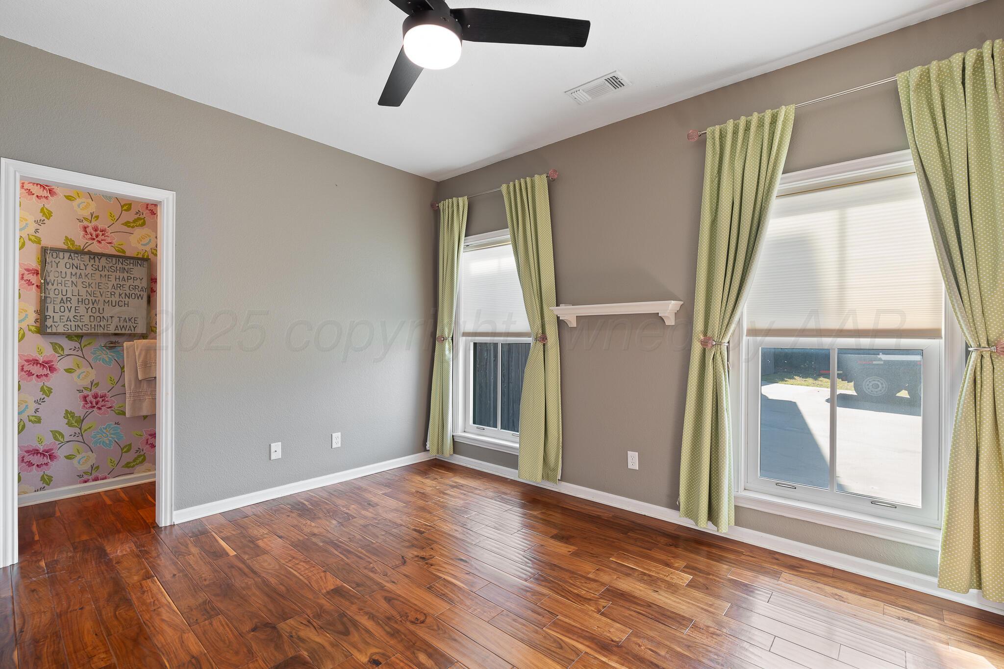 17301 Spring Lake Drive Canyon, TX 79015 - Photo 28 of 62 an empty room with wooden floor and windows
