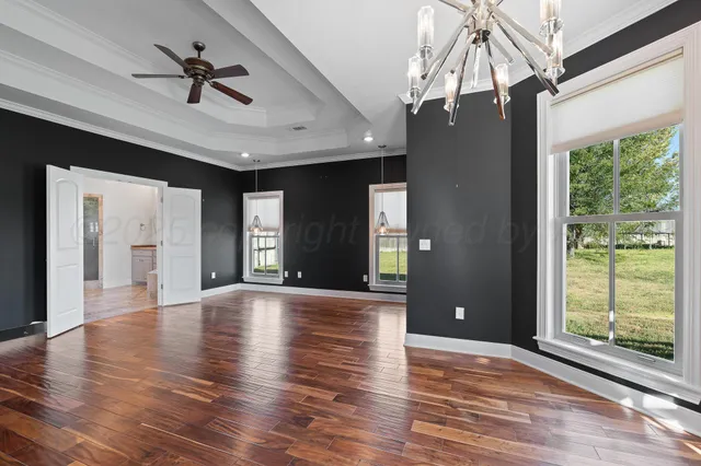a view of an empty room and window with wooden floor